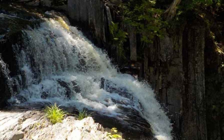 a waterfall runs in the Appalachian mountains of maine